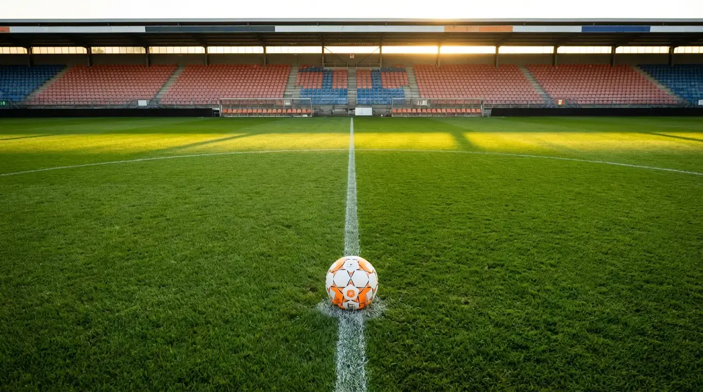 Nederlands voetbalveld met groene grasmat en een wedstrijdbal op de middenstip